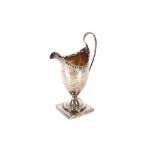 A George III silver pedestal cream jug, having naïve foliate engraved decoration, spread foot set to