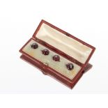 A cased set of four yellow metal garnet and diamond dress buttons