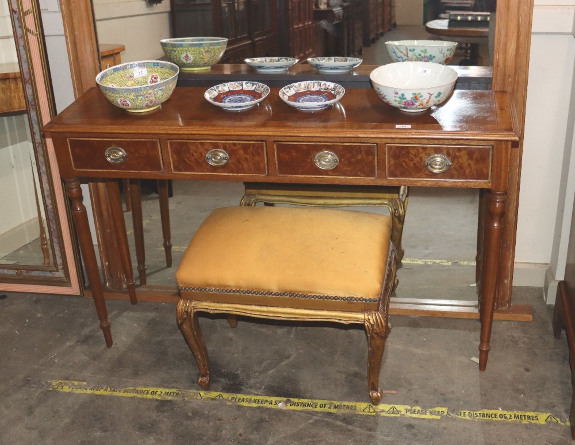 A walnut and cross banded hall table, fitted four drawers raised on turned tapering supports,