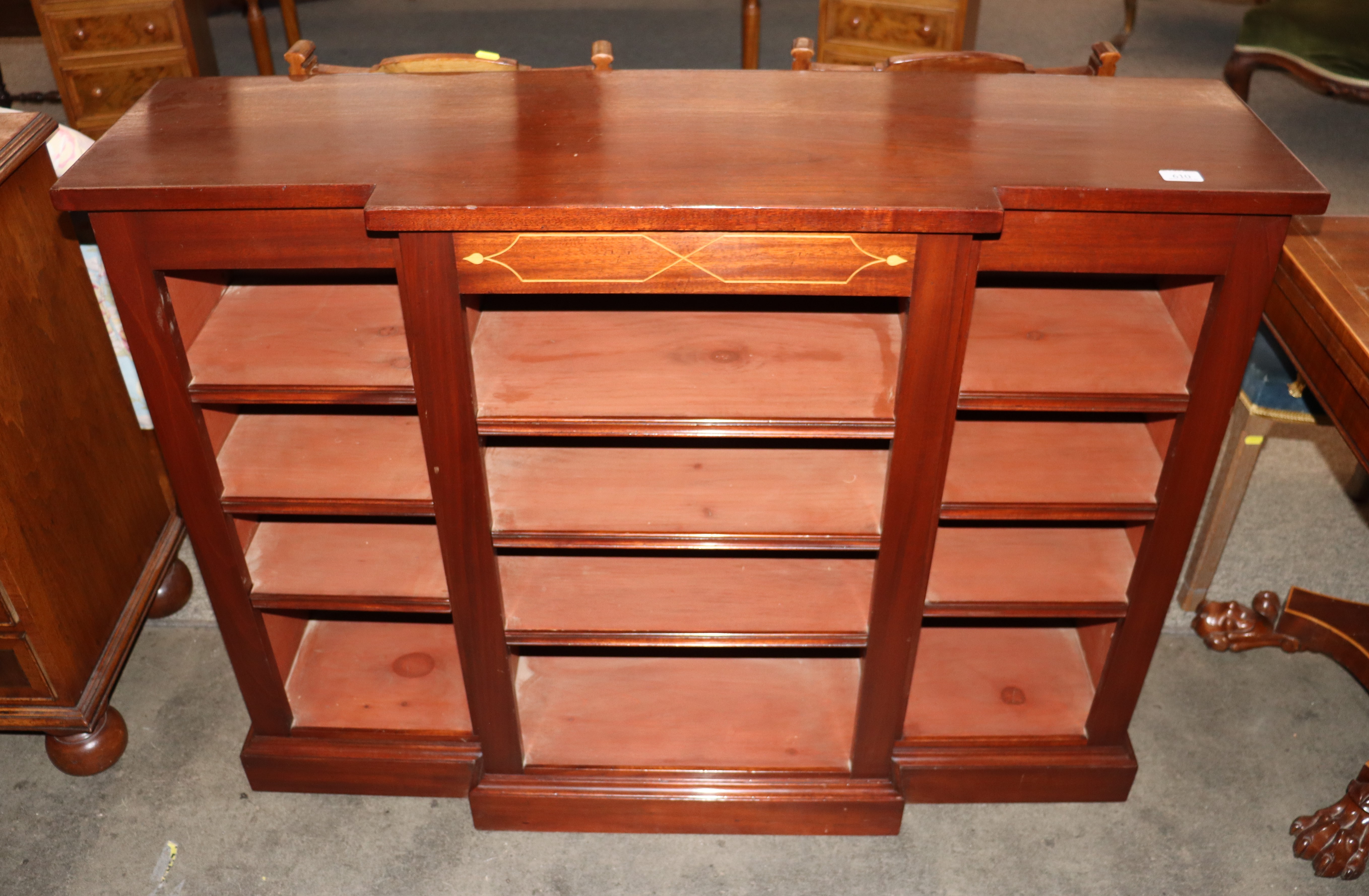A mahogany dwarf breakfront bookcase, fitted adjustable shelves raised on a platform plinth, 122cm