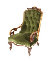 A Victorian walnut framed spoon back armchair, having carved foliate cresting, buttoned green Dralon