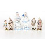 A Meissen style porcelain figure of a young boy; three German porcelain figures of two maids and a