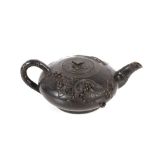 A Chinese black glazed teapot of squat form with raised animal and berry decoration, leaf shaped