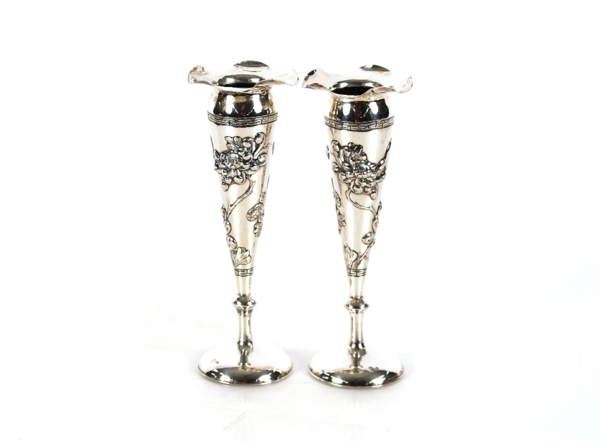 A pair of slender Chinese silver trumpet shaped spill vases, decorated with hand worked floral and