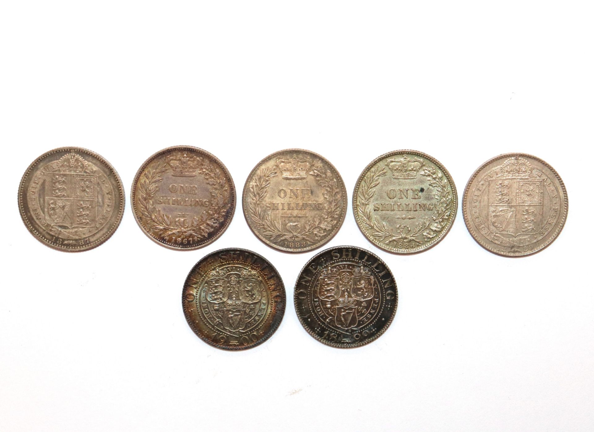 Seven Victorian shillings, ranging from 1867-1900