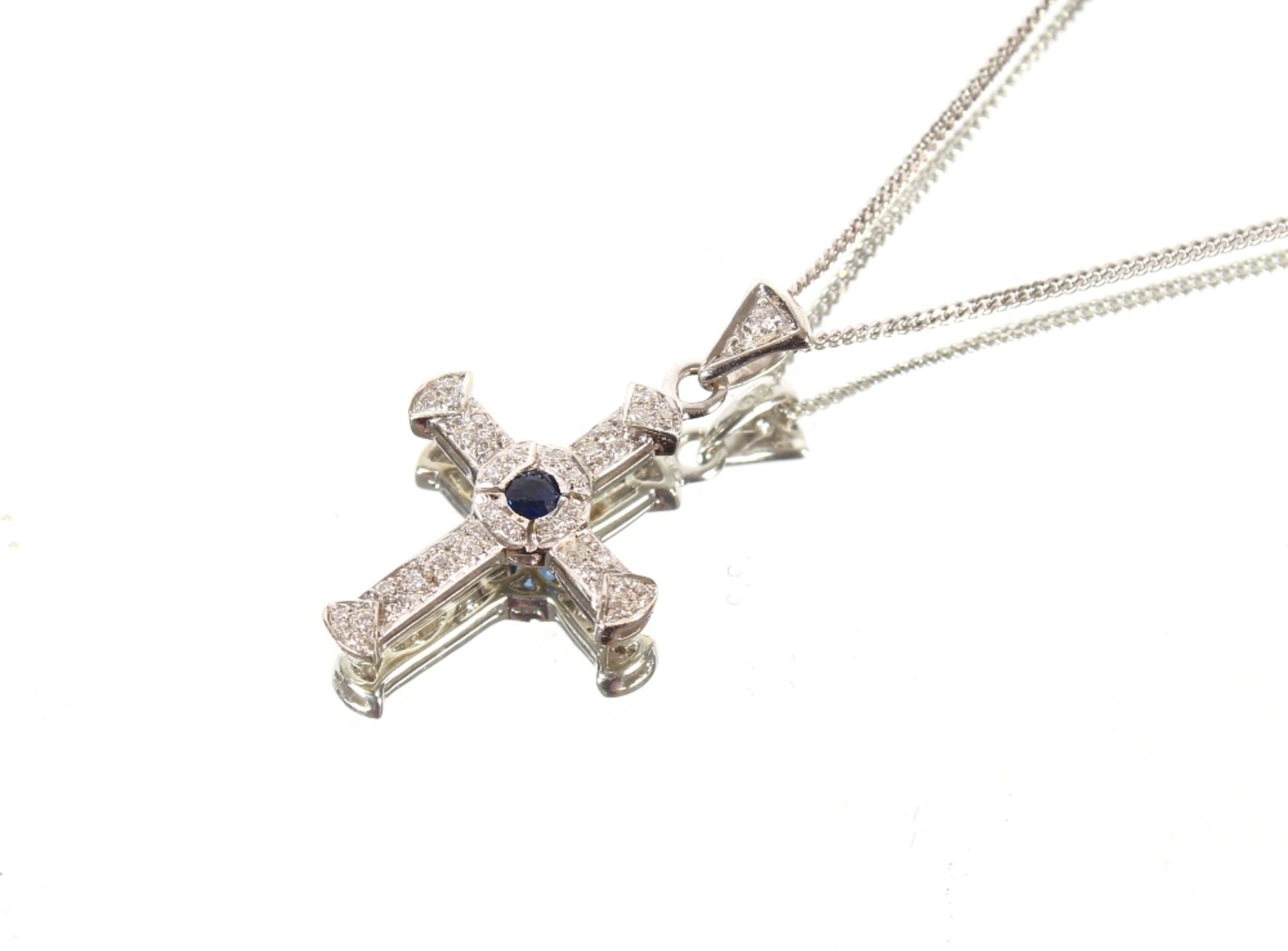 An 18ct white gold diamond and sapphire set cross and fine link chain, 6.6gms