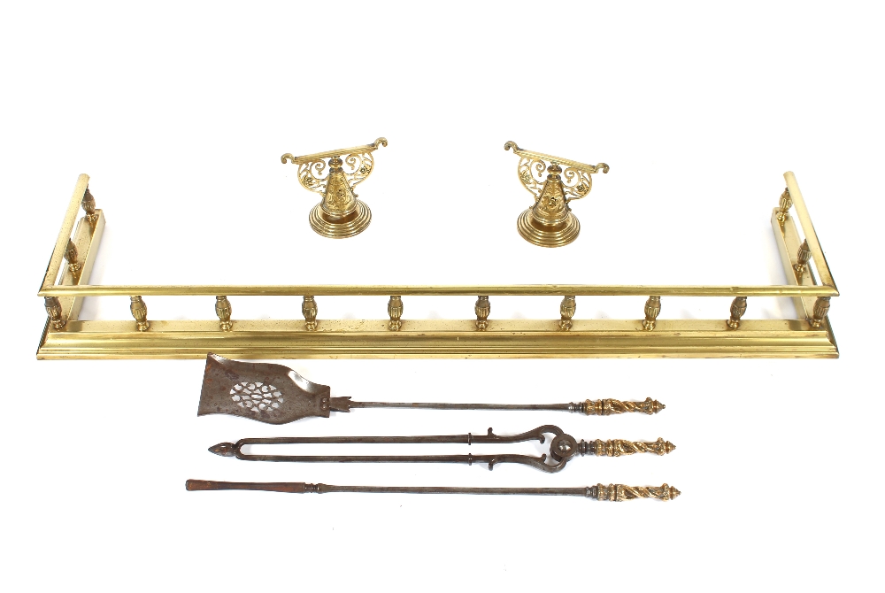 A Victorian brass fender, 139cm wide; a set of three steel and brass fire implements; a pair of