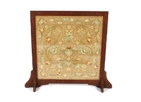 A large 19th Century carved oak framed fire screen with crewel work panel, depicting trailing