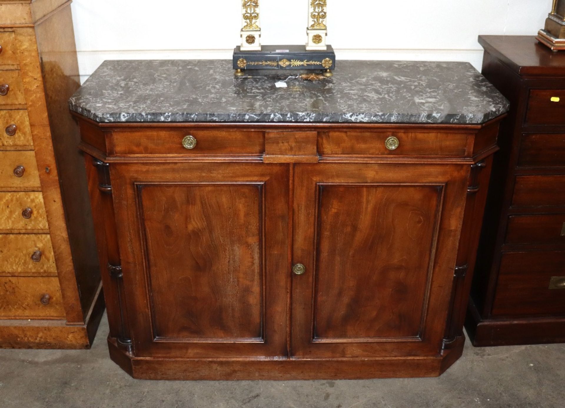 A 19th Century mahogany side cabinet surmounted by a grey marble top above two short drawers,