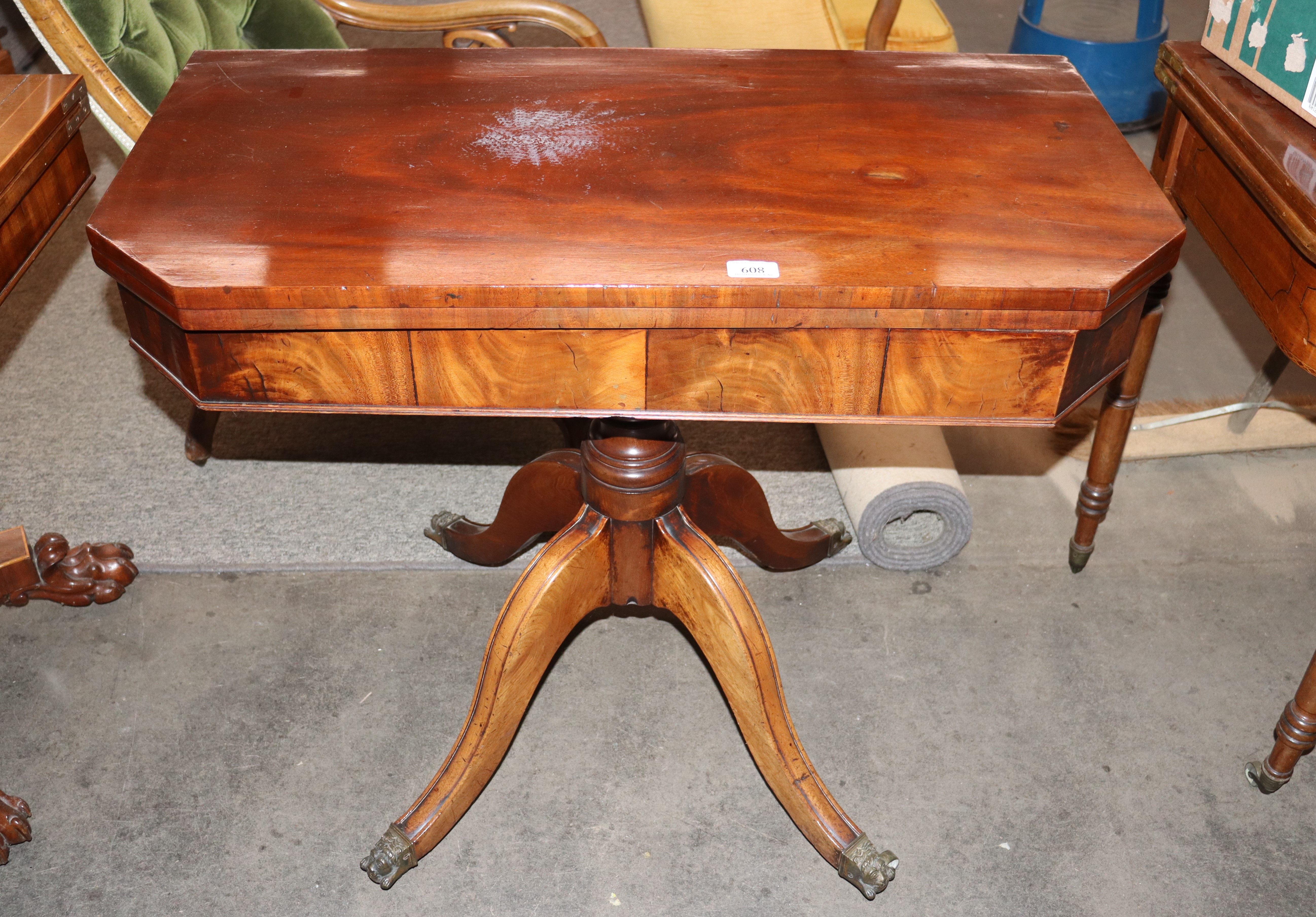 A 19th Century mahogany fold over tea table, the canted corner swivel top raised on a turned