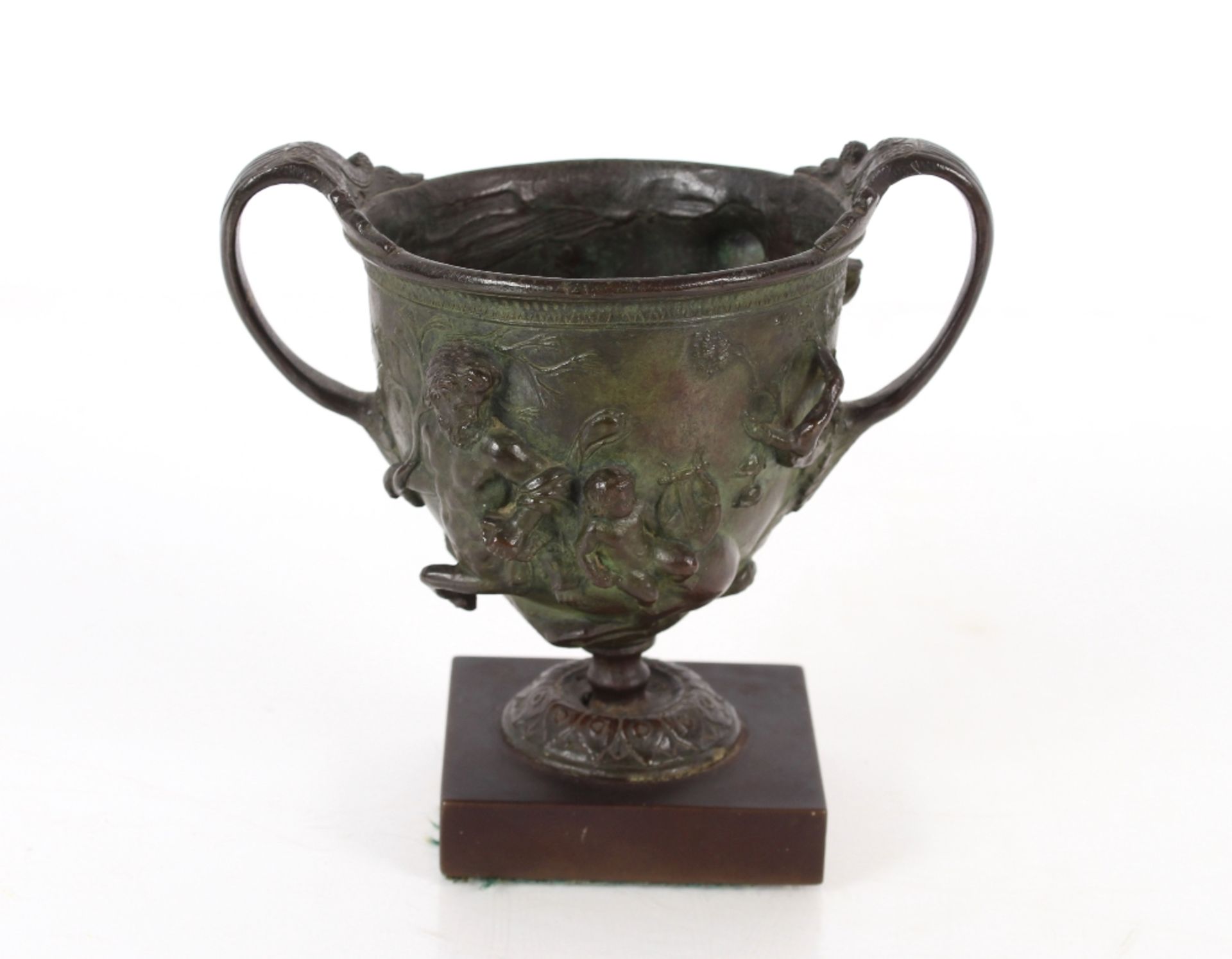 An antique bronze twin handled cup, having classical decoration of centaurs and cherubs raised on