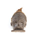 A carved wooden Ethnic face mask with plaited straw work decoration, the forehead with carved motif,