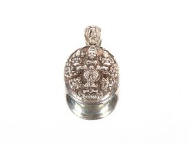 A large white metal Asian locket, having raised decoration of deities and flowers