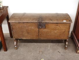 A 17th Century oak coffer, of ark shape having iron strap hinges and hasps above shaped style end