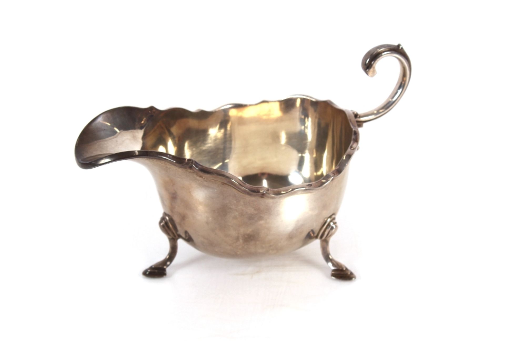 A silver sauce boat, Birmingham 1933, retailed by Harrods, having flying C scroll handle and