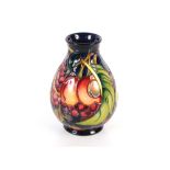 A Moorcroft fruit decorated baluster vase, with original box, 20cm high