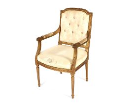 A pair of French gilt elbow chairs, having upholstered button backs raised on leaf decorated