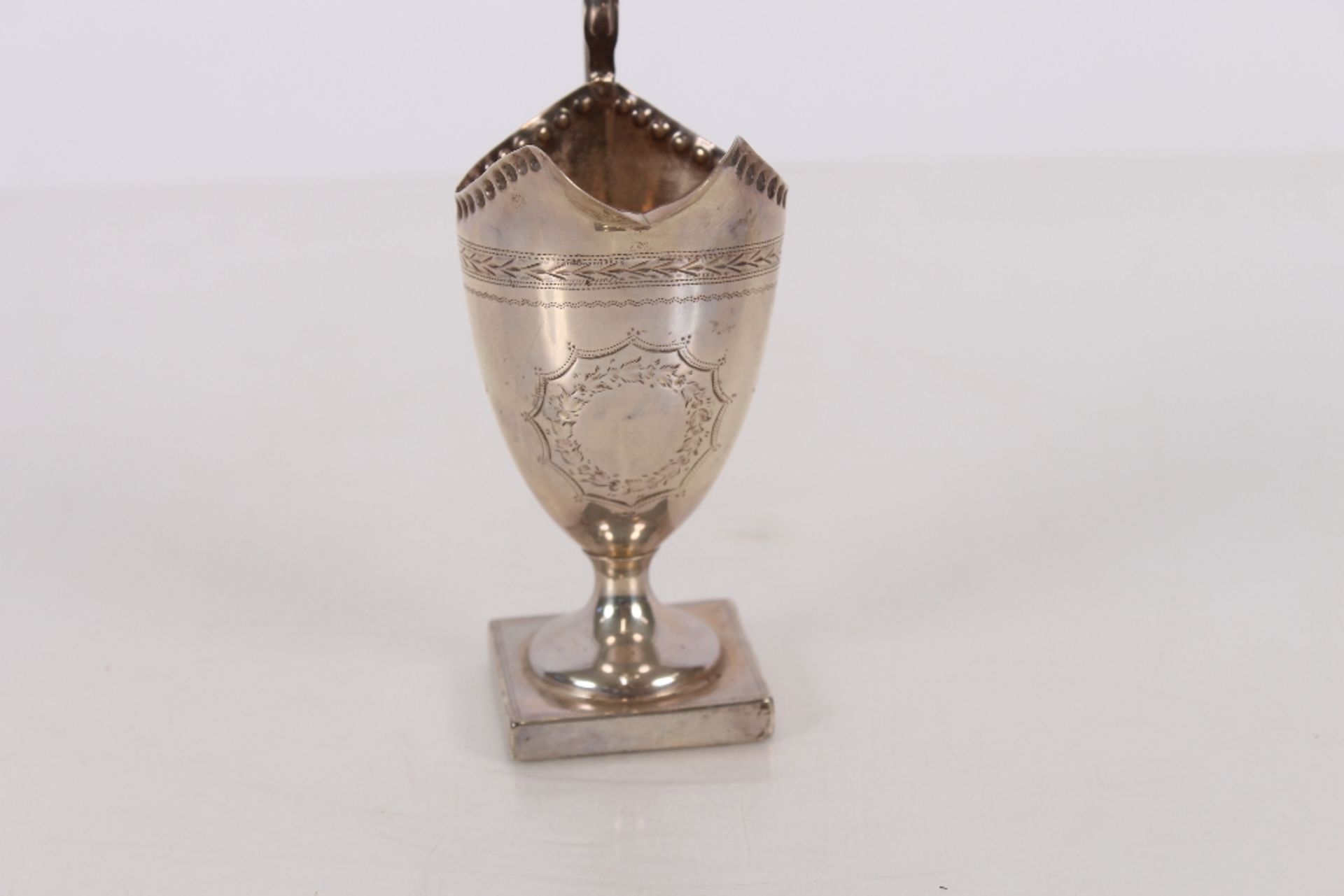 An Edwardian silver pedestal cream jug, having foliate line decoration, spread foot and square base, - Image 2 of 3