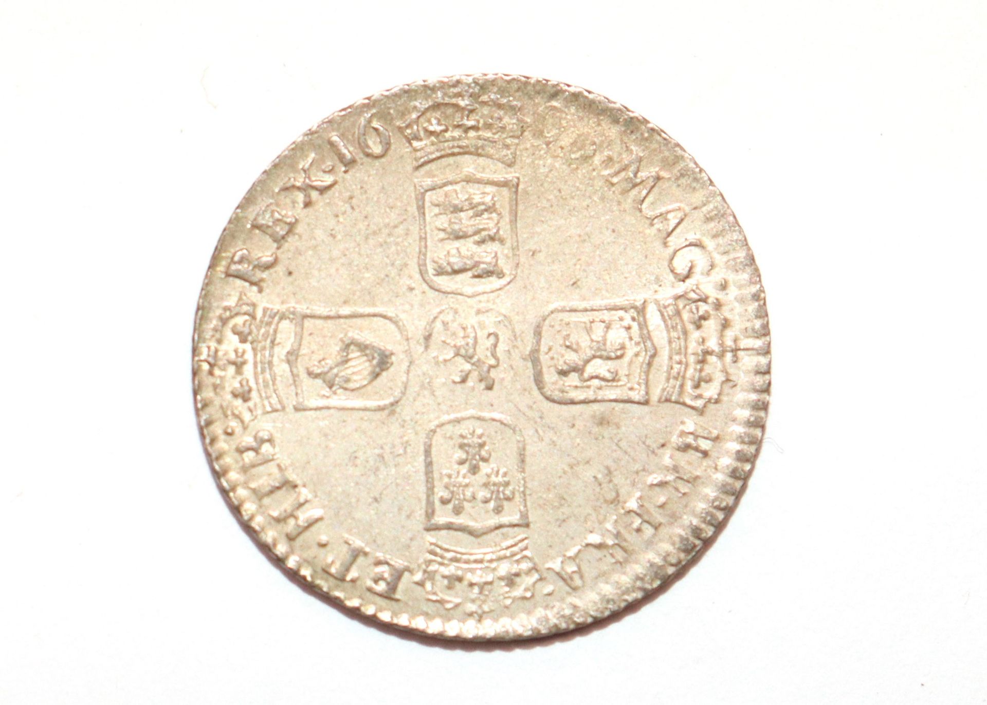 A William III sixpence (date worn)