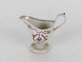 A Newhall porcelain cream jug of helmet shape, raised on a circular spread mis-shapen foot, old