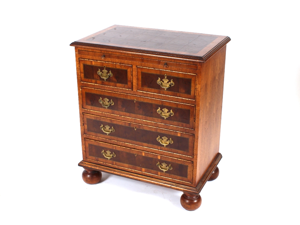 A George II style walnut and cross banded bachelors chest, fitted with a brushing slide, two short