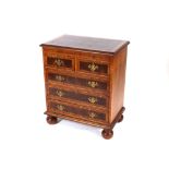 A George II style walnut and cross banded bachelors chest, fitted with a brushing slide, two short