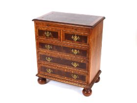 A George II style walnut and cross banded bachelors chest, fitted with a brushing slide, two short