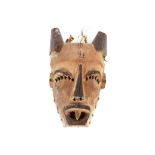 An Ethnic carved face mask with plaited straw work back, painted and carved pierced decoration