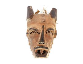 An Ethnic carved face mask with plaited straw work back, painted and carved pierced decoration