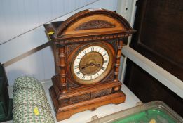 An Edwardian carved walnut mantel clock