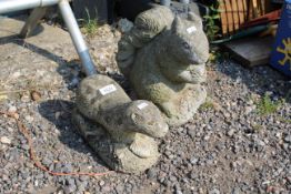 Two stone garden animals in the form of an otter a