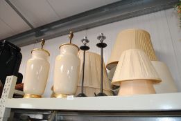 A pair of cream and gilt pottery table lamps and s