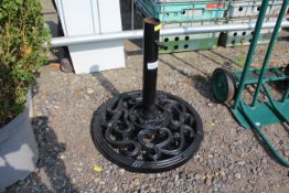 An ornate cast iron black painted parasol base