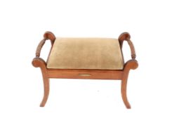 A mahogany music stool, in the Regency style fitted lifting seat compartment flanked by rope twist