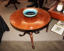 A circular Georgian Mahogany snap top occasional table, raised on a turned column and tripod base,