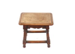 An antique oak joint stool raided on turned supports united by stretchers, 47cm wide