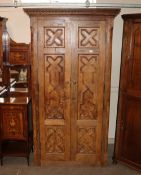 A late 19th Century Continental carved oak cupboard, the interior shelves enclosed by geometric
