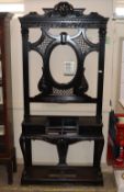 A Victorian ebonised mahogany carved hall stand, raised on cabriole claw and ball supports united by