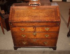 A Georgian oak bureau, the cross banded fall front opening to reveal and interior arrangement of