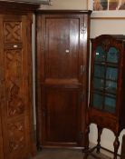 An antique oak and mahogany cross banded free standing double corner cupboard, the interior