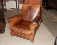 Early 20th Century leather club chair, raised on bun front supports terminating in castors