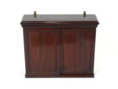 An Edwardian mahogany wall cupboard, the interior adjustable shelves enclosed by a pair of sliding
