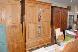 A large stripped pine wardrobe, having fielded pan