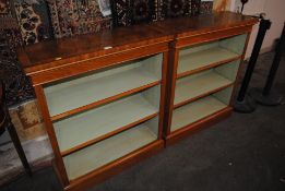 A pair of walnut cross banded open fronted bookcas