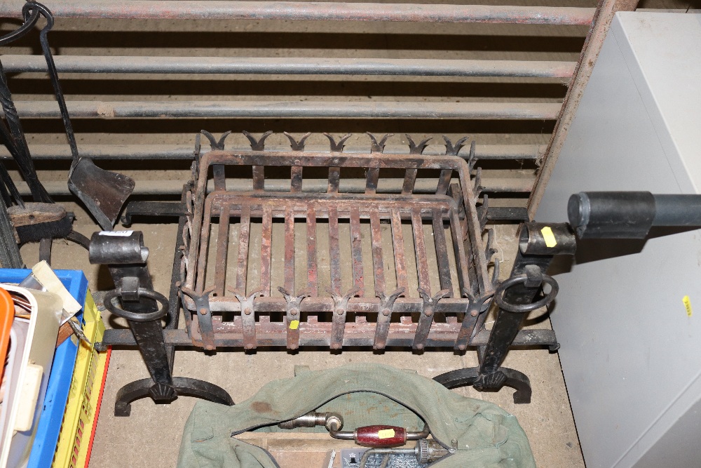 A cast iron fire basket with a pair of fire dogs