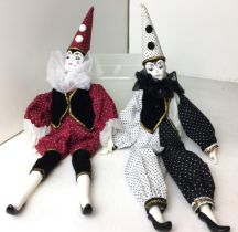 Plastic box containing two composite Pierrot dolls - one black and white and one black and burgundy