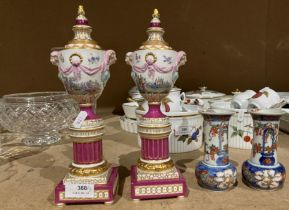 Pair of reproduction pink and gilt patterned vases on pedestals with long stopper lids which if