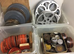 Four plastic boxes containing old movie films and empty reels (saleroom location: Z05 floor)