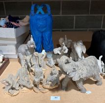 A collection of resin model elephants and a resin model of a pair of blue overalls (saleroom