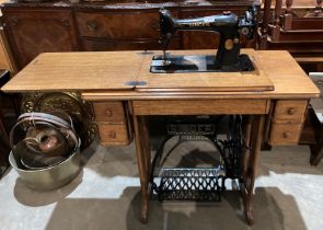 A Singer manual sewing machine with cast metal treadle case and in oak base no.